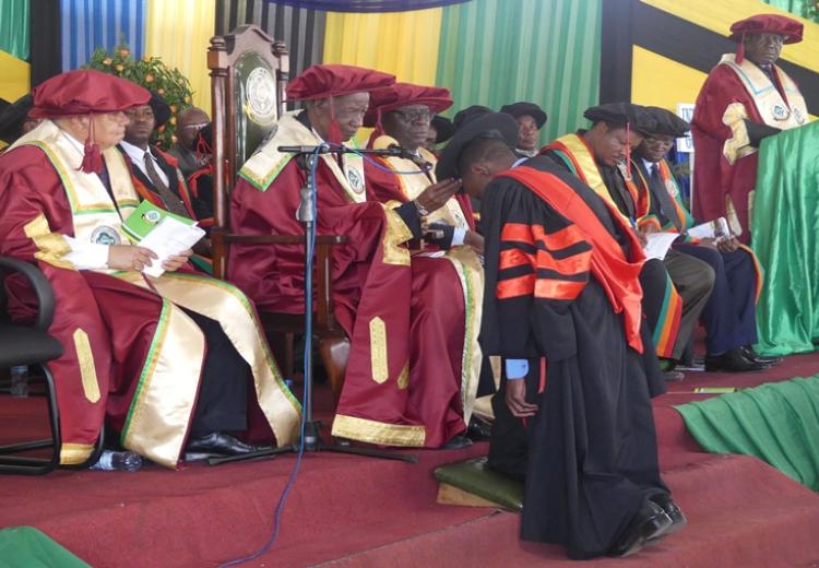 In this picture, Chancellor of Sokoine University of Agriculture (SUA) Hon. Joseph Sinde Warioba (Right) conferring PhD awards to one of graduate during 34th SUA graduation Ceremony which was held on 23rd November 2018 at Nelson Mandela Freedom Square in Solomon Mahlangu Campus located in Mazimbu, Morogoro