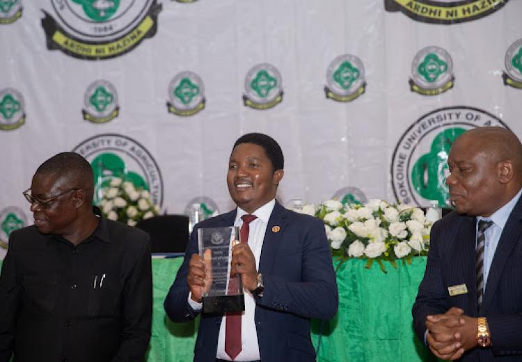 Waziri wa Nchi Ofisi ya Makamu wa Rais, Muungano na Mazingira Dkt.  Selemani Jafo (katikati) akiwa na tuzo aliyokabidhiwa katika Majalisi ya SUA