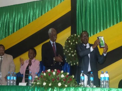  Prof. Gerald C. Monela showing off a token awarded to him during his farewell party. Looking on from right to left is The Chancellor of Sokoine University of Agriculture Hon. Judge (retired) Joseph Sinde Warioba, Deputy Chairperson of SUA Council Prof. Ester Mwaikambo and SUA’s Deputy Vice Chancellor – Administration and Finance Prof. Yonika Ngaga. 