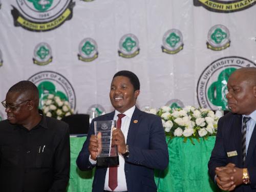 Waziri wa Nchi Ofisi ya Makamu wa Rais, Muungano na Mazingira Dkt.  Selemani Jafo (katikati) akiwa na tuzo aliyokabidhiwa katika Majalisi ya SUA