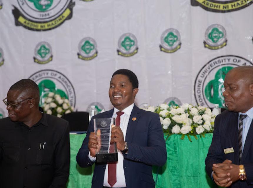 Waziri wa Nchi Ofisi ya Makamu wa Rais, Muungano na Mazingira Dkt.  Selemani Jafo (katikati) akiwa na tuzo aliyokabidhiwa katika Majalisi ya SUA